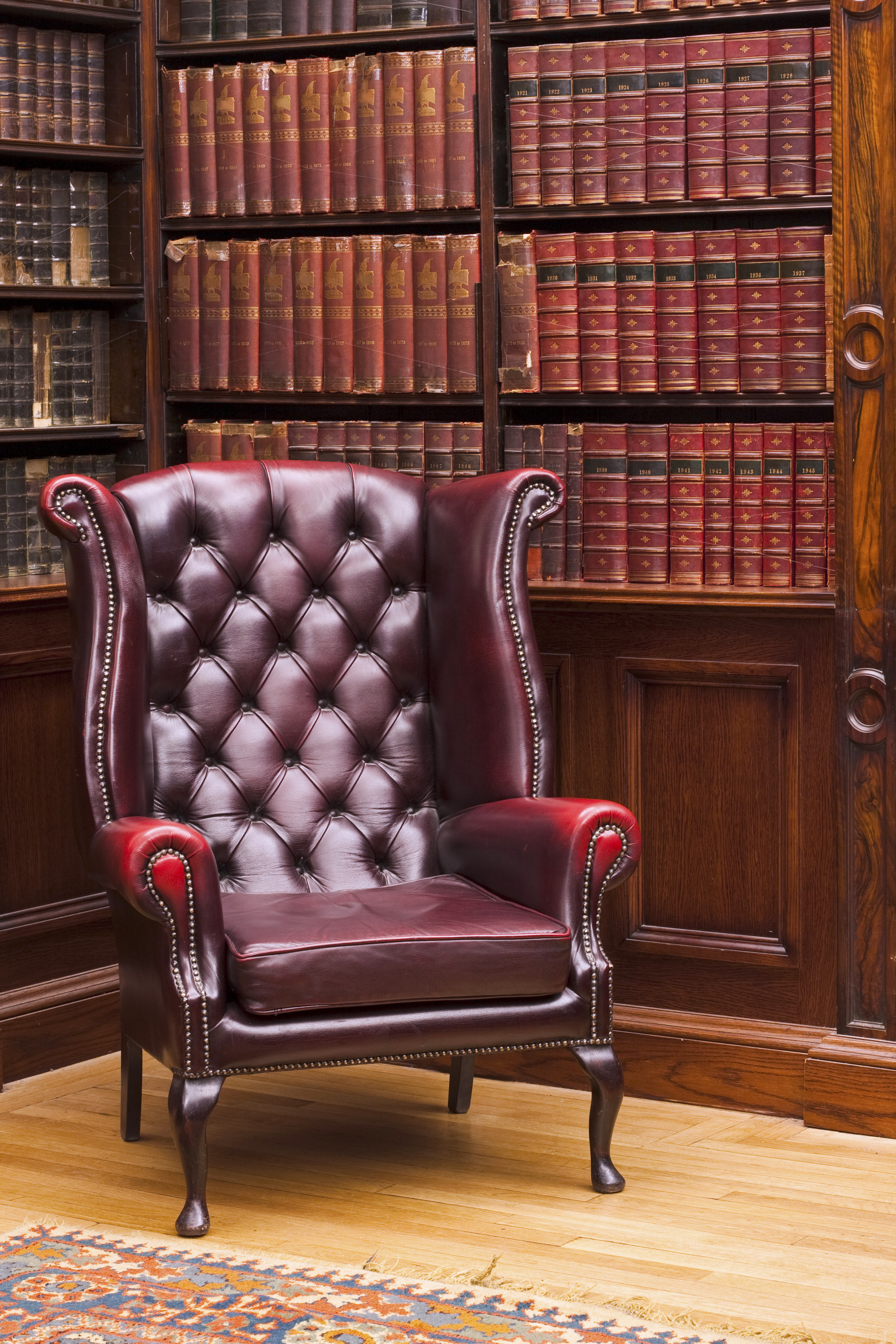 Traditional Chesterfield chair in classical library room