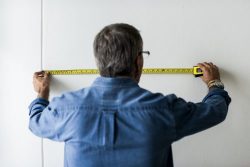 a man measuring a wall