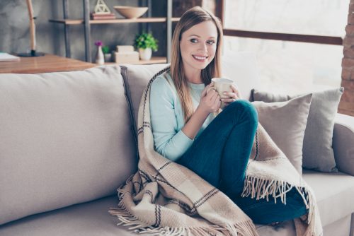 a woman wearing a blanket to keep warm